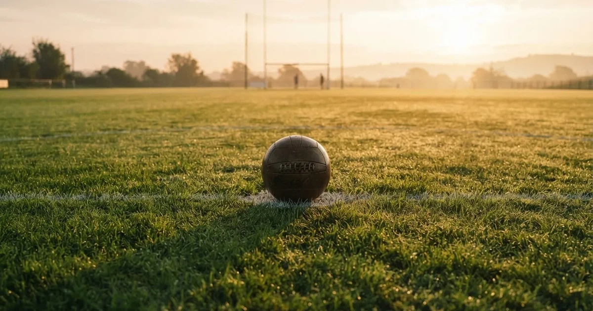 A ball on the centre spot of a grass pitch in morning light