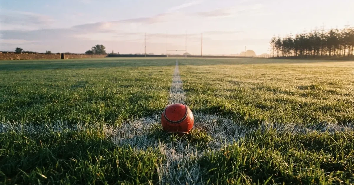 A ball on the centre spot of a grass pitch in morning light