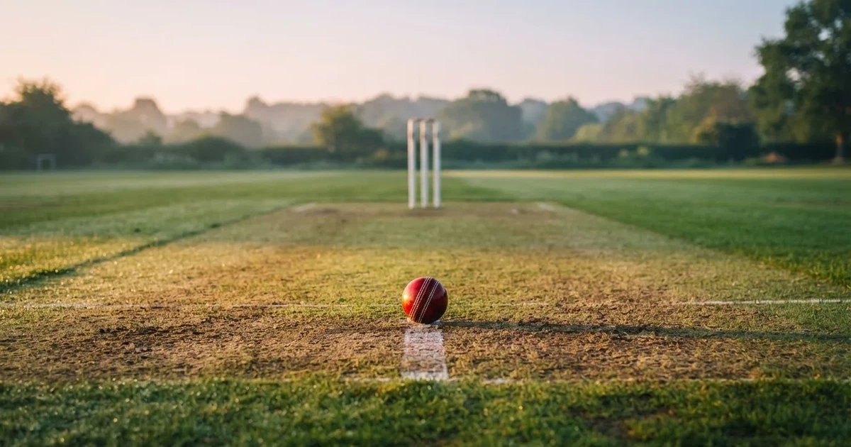A ball on the centre spot of a grass pitch in morning light