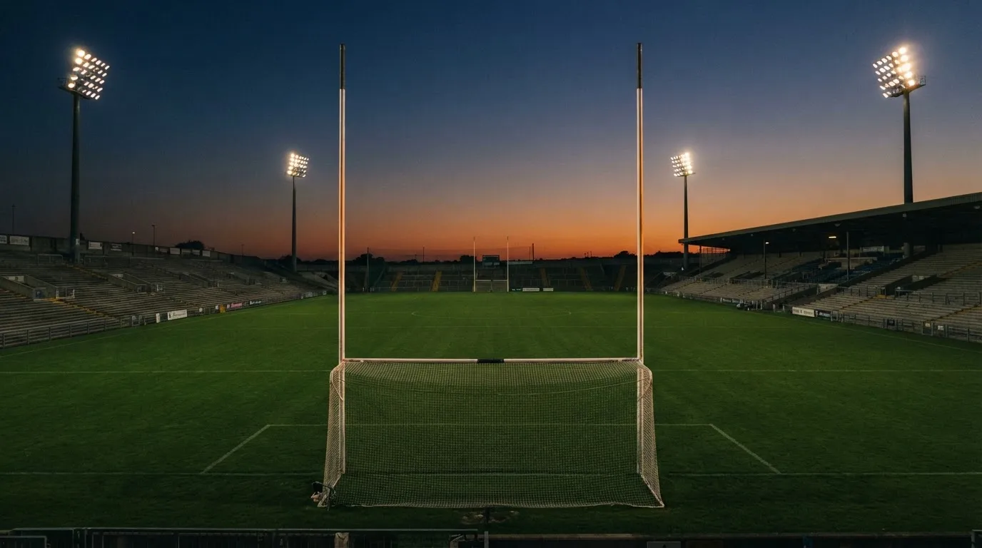 An empty football stadium with floodlight masts at dusk