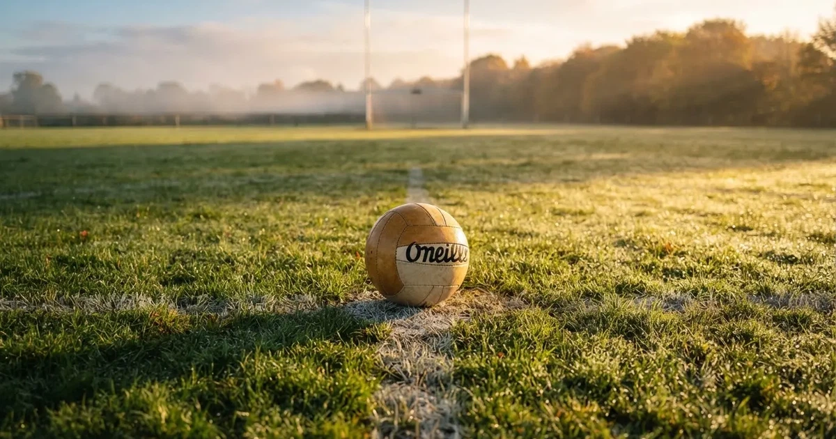 A ball on the centre spot of a grass pitch in morning light