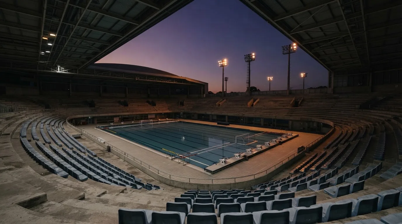 An empty football stadium with floodlight masts at dusk